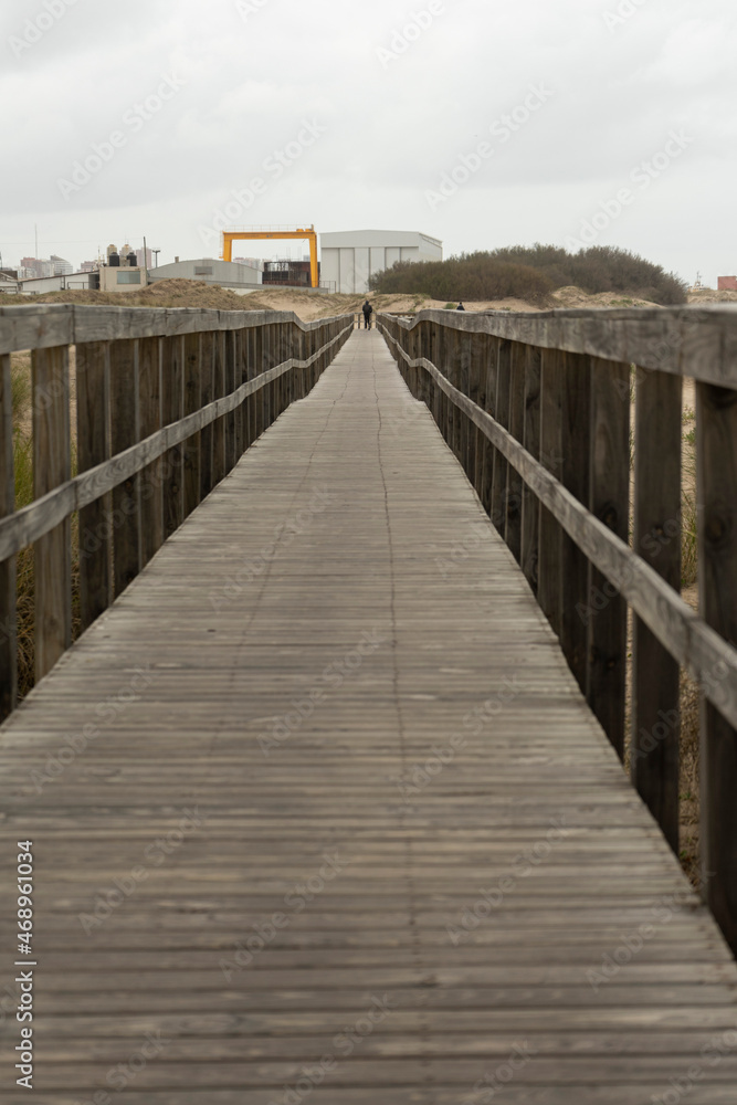 man standing at the end of a wooden path man standing at the end of a wooden path