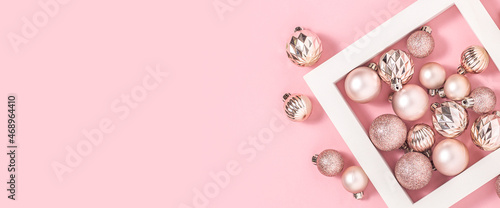 Square white podium and pink decorative balls on a pink background. Top view, flat lay. Banner.
