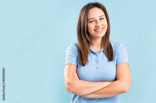 Confident smiling young woman with crossed hands on chest © dragonstock