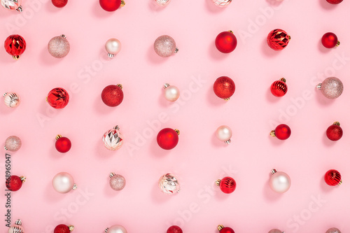 Background with pink and red decorative balls on a pink background. Top view, flat lay.