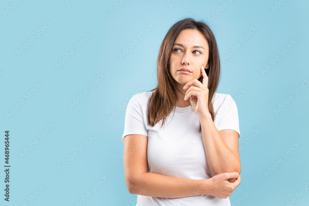 Young woman thinking creating plan over bright blue background Young woman thinking creating plan over bright blue background