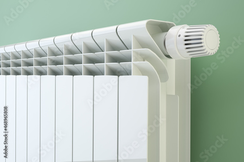 Heater radiator with thermostat on blue wall, 3d illustration