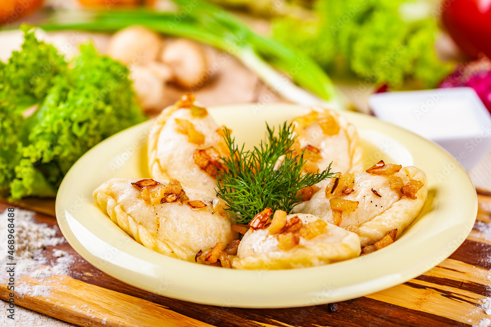 Vareniki with potatoes and mushrooms decorated with fried onion and dill Vareniki with potatoes and mushrooms decorated with fried onion and dill