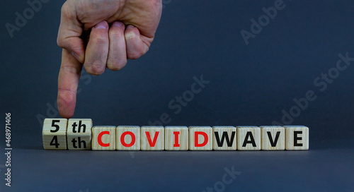 Symbol for a fifth wave of the covid-19 corona virus. Doctors turns cubes and changes words 4th covid wave to 5th covid wave. Beautiful grey background. Fifth wave of the covid-19 concept. Copy space.