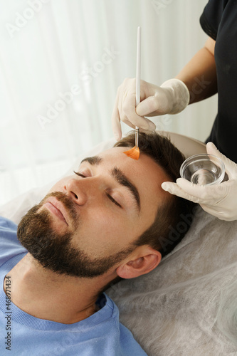Young man during peeling treatment in beauty clinic
