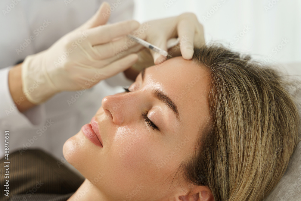 Naklejka premium Woman during facial filler injections in aesthetic medical clinic
