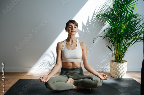 Fotografie Relaxed 30 year old woman practicing yoga, meditating