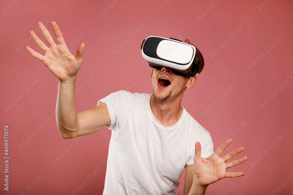 Young Man wearing virtual reality goggles over pink background. 3D virtual lifestyle concept. Young Man wearing virtual reality goggles over pink background. 3D virtual lifestyle concept.