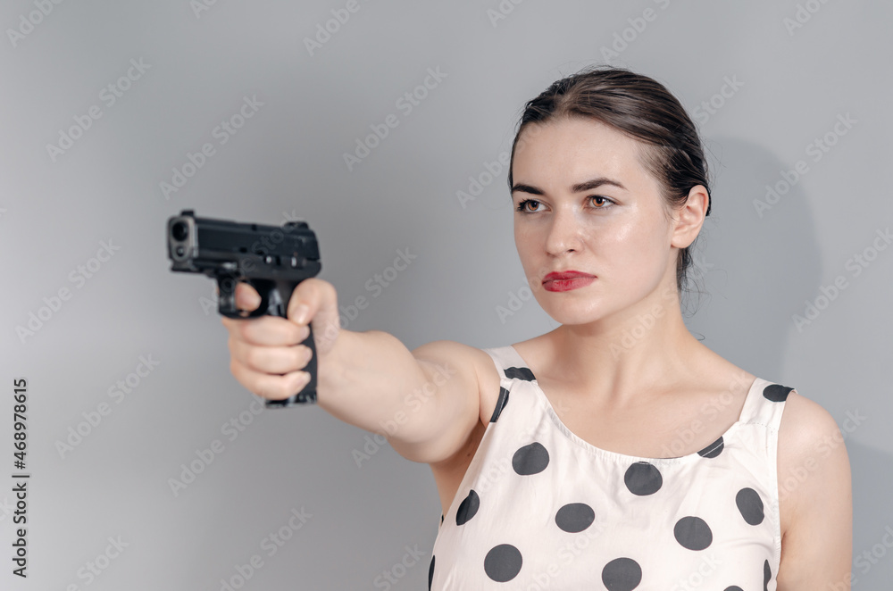 Portrait of a beautiful woman. Holds a gun. Aims with a pistol. Portrait of a beautiful woman. Holds a gun. Aims with a pistol.