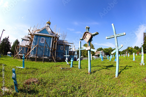 Ternopil region Ukraine, August 2021, Church cemetery of wooden and stone blue crosses, reconstruction of the old church. The concept of Orthodoxy.