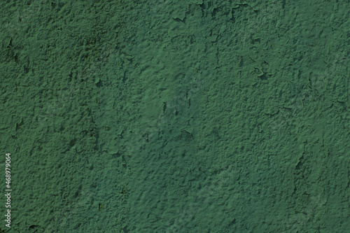 Old concrete wall covered with green paint.
