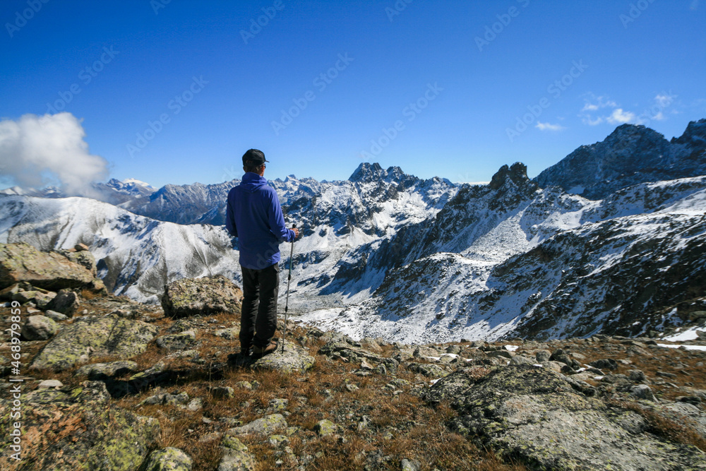 A tourist admires the view of the Caucasus Mountains, Dombay, Russia.