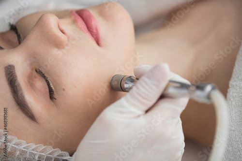 Diamond microdermabrasion, peeling cosmetic. woman during a microdermabrasion treatment in beauty salon photo