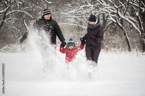 Happy family running on snow in winter