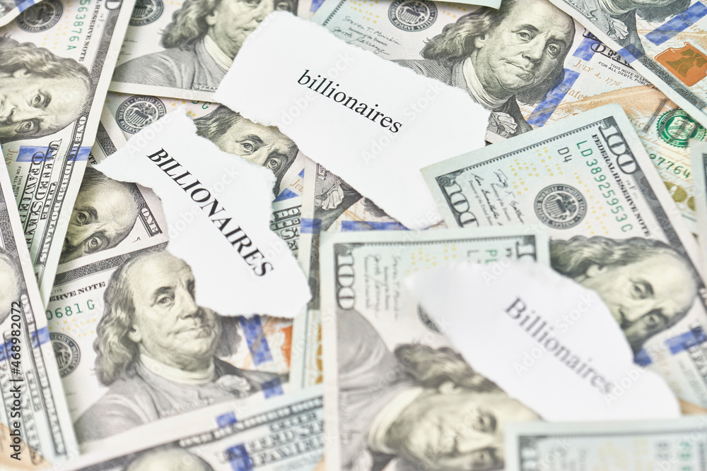 Billionaires income tax. Pile of us dollar banknotes and pieces of paper with Billionaires text. Billionaires income tax proposed in US Senat Billionaires income tax. Pile of us dollar banknotes and pieces of paper with Billionaires text. Billionaires income tax proposed in US Senat