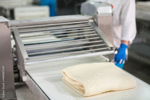 Foto Raw puff pastry on the conveyor before freezing