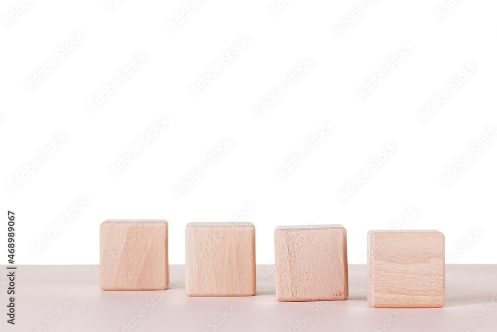 Obraz premium Four wooden cubes on a white background