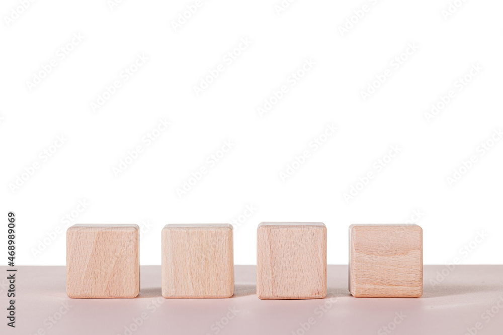 Obraz premium Four wooden cubes on a white background