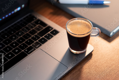 Morning espresso at work - A black coffee on top of a laptop