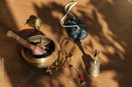 Tibetan singing bowls, bells, for meditation and relaxation on wooden floor. Hamdmade percussion music instruments. Sound massage and healng. photo