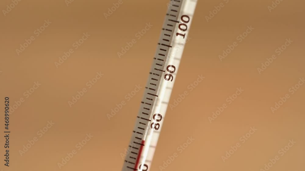 Close up of a thermometer rising to over 100 degrees