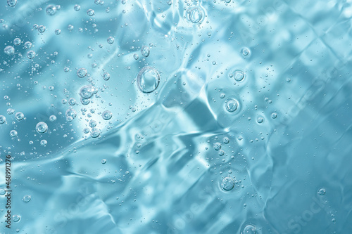 Close up macro Aloe vera gel cosmetic texture blue background with bubbles.