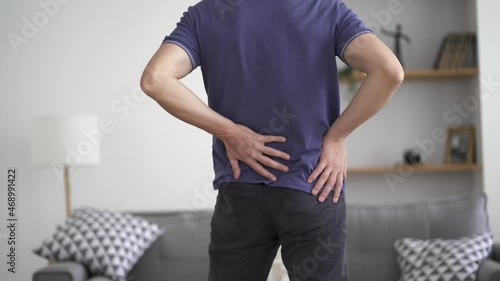 Back pain, kidney inflammation, man suffering from backache at home, health problems concept