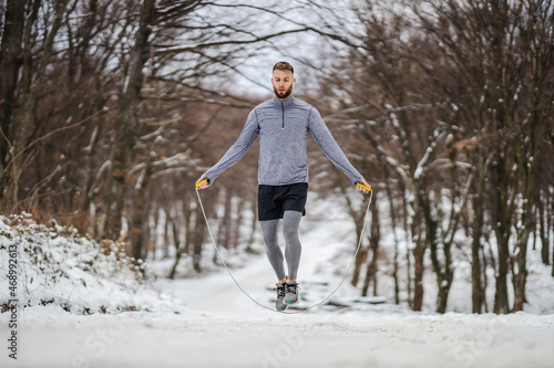 Fit sportsman jumping the rope in nature at snowy winter day. Winter fitness, cardio exercises © dusanpetkovic1