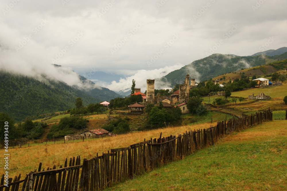 mountain landscape in the fog. in the foreground is a rustic hand-made fence against the backdrop of a mountain landscape