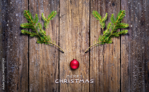 Christmas Concept - Reindeer Made With Fir Branches And Red Ball On Wooden Plank photo