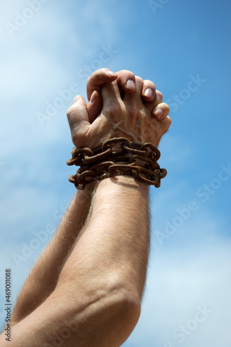 Chained hands praying for help