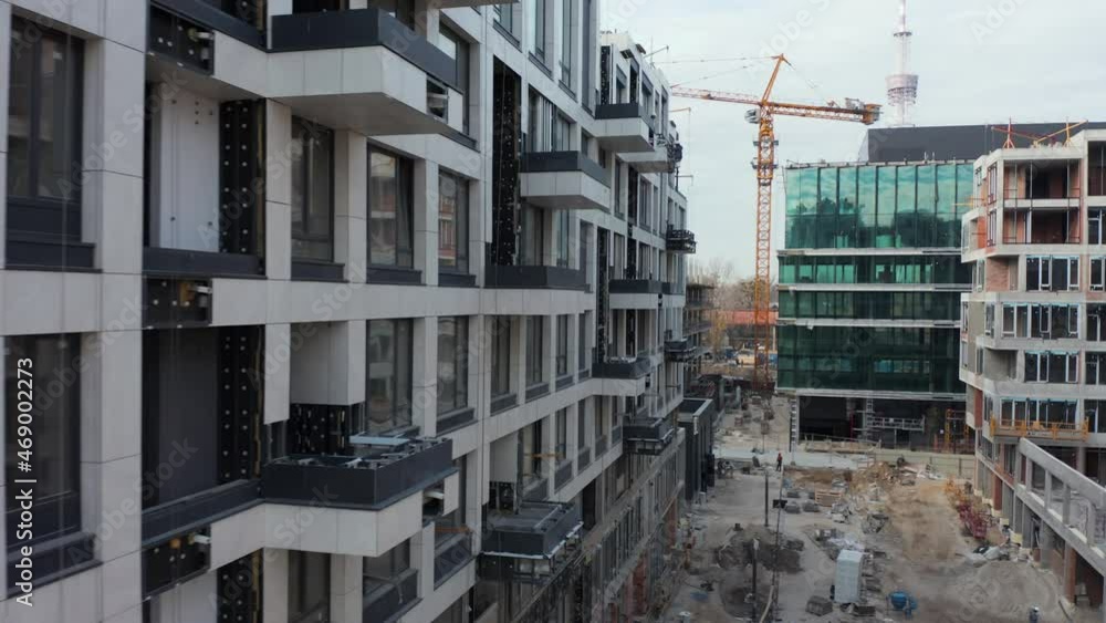 High crane works on building site with a house. Urban Construction Site, Aerial View. Construction area, building area, site area from above. New appartments getting built High crane works on building site with a house. Urban Construction Site, Aerial View. Construction area, building area, site area from above. New appartments getting built