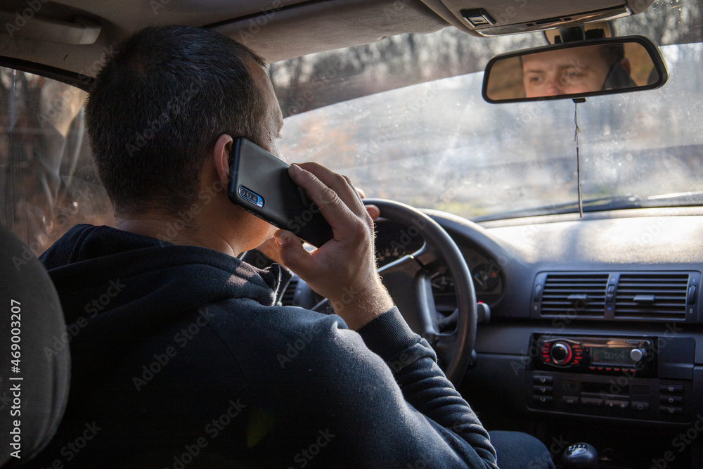 Driver with a phone behind the wheel Driver with a phone behind the wheel