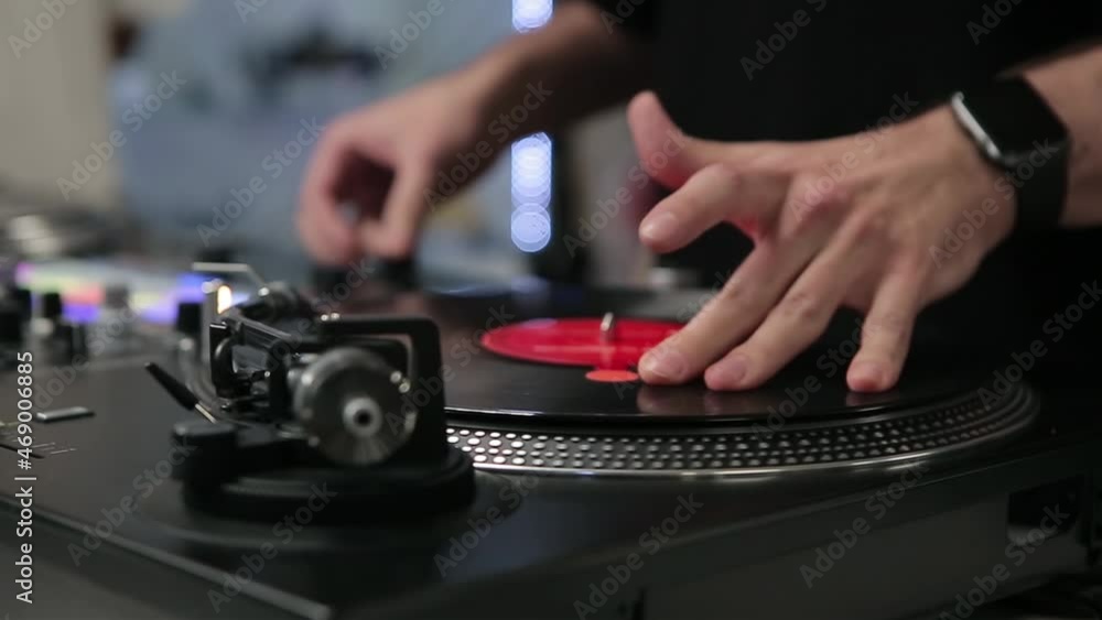 Dj scratching vinyl records on turn table player in close up video club