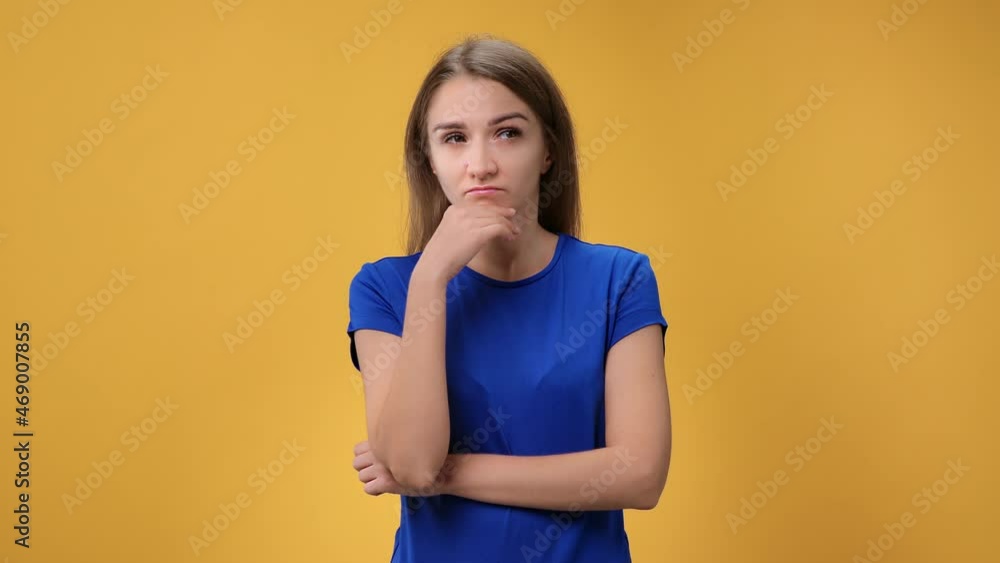 Portrait perplexed young woman thinking brainstorming solving problem posing isolated on orange Portrait perplexed young woman thinking brainstorming solving problem posing isolated on orange