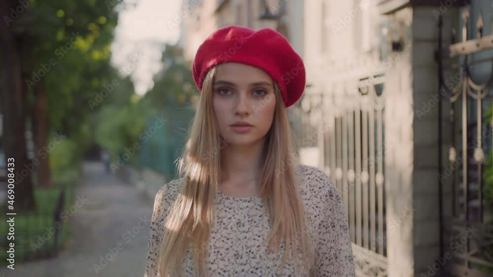 Elegant young attractive caucasian woman in red beret looking at camera outdoors. Beautiful stylish lady on autumn street. Fashion model. Elegant young attractive caucasian woman in red beret looking at camera outdoors. Beautiful stylish lady on autumn street. Fashion model.