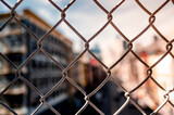 Metal fence grid closeup. Chain link fence on blur building city background.