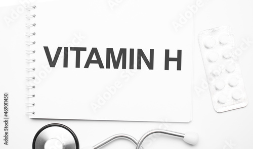 On the tablet for writing the text Vitamin h next to the stethoscope and white tablets.
