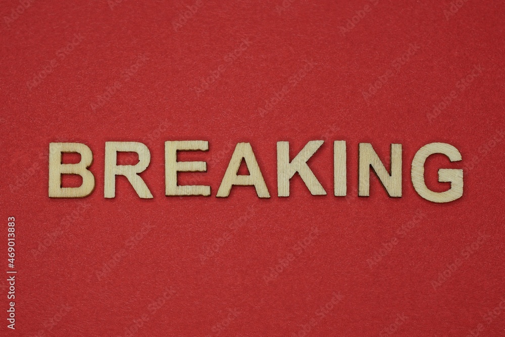 text the word breaking from gray wooden small letters on an red table text the word breaking from gray wooden small letters on an red table