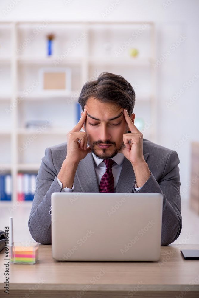 Young male employee working in the office Young male employee working in the office