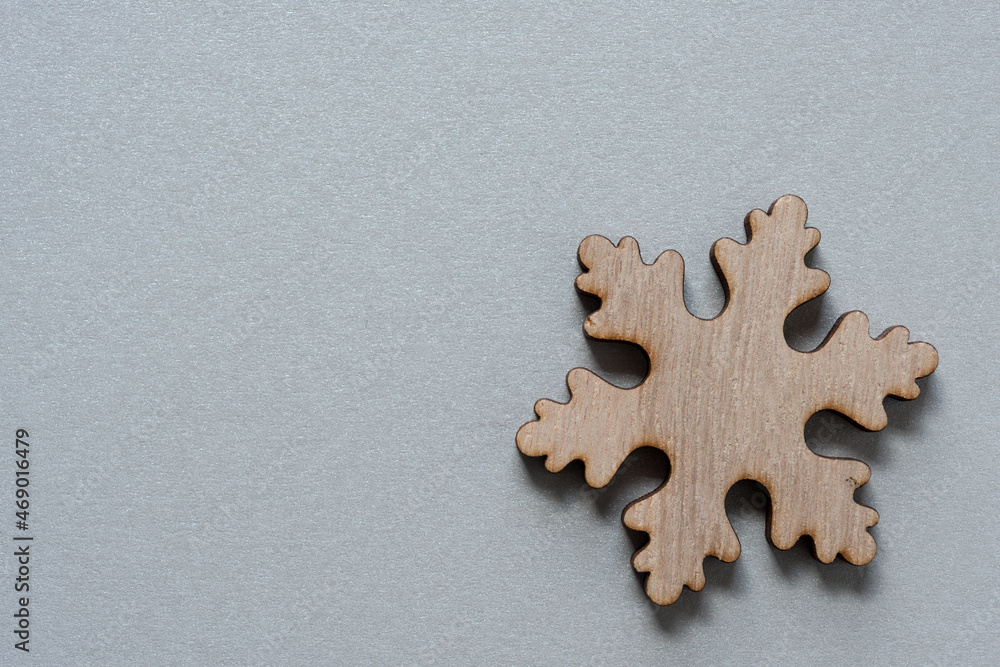 isolated wooden christmas snowflake on gray-silver paper isolated wooden christmas snowflake on gray-silver paper