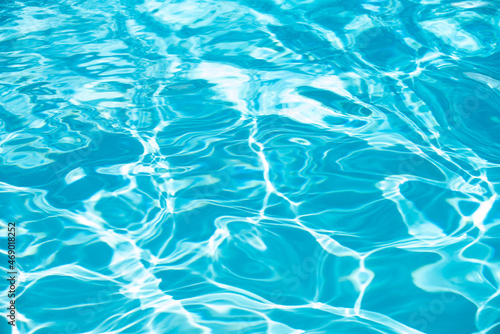 Background of blue water in swimming pool with sun reflection, ripple water wave in pool. Clear water background.