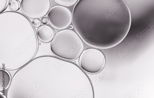 Oil droplets ,water surface with light efface on grey background.