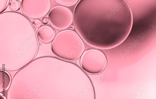 Abstract  water and oil droplets to creating circle and bubble shape on pink greadient background.