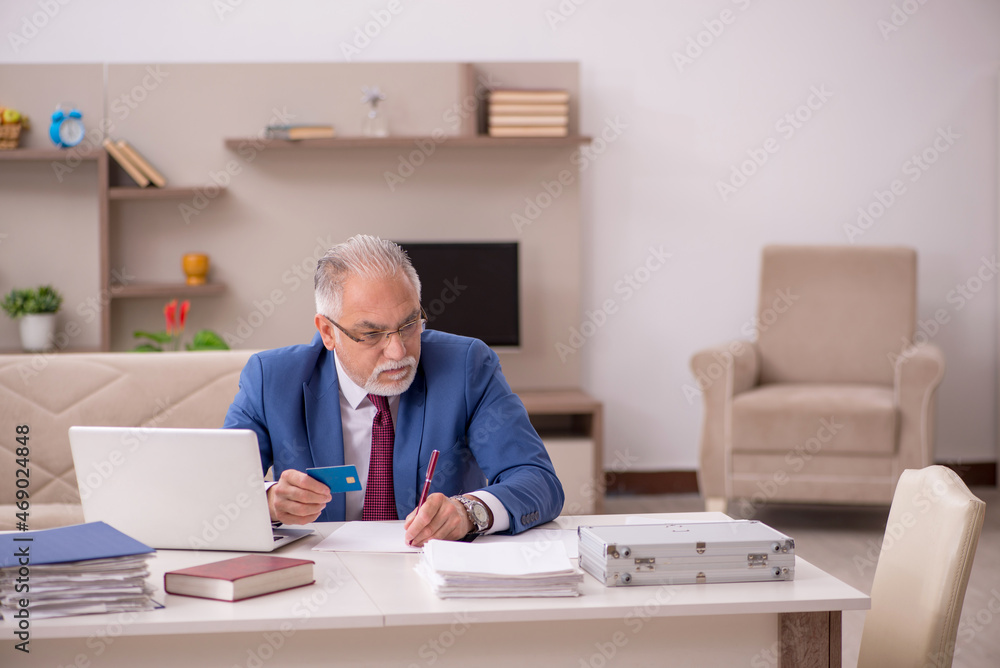 Old male employee in remuneration concept at home Old male employee in remuneration concept at home