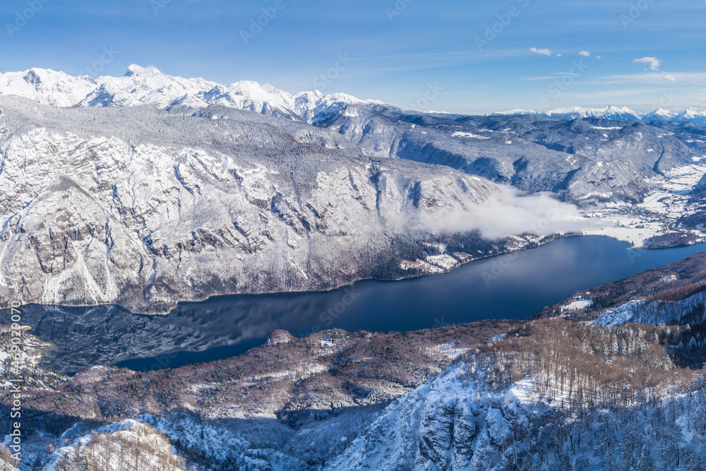 Fototapeta premium A view of the Lake Bohinj and the surrounding mountains in winter
