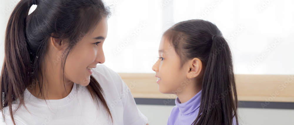 Young asian mom and daughter smiling and eye contact together with care in room, face of mother and girl looking eye with relationship and bonding, emotion and expression, family and love concept. Young asian mom and daughter smiling and eye contact together with care in room, face of mother and girl looking eye with relationship and bonding, emotion and expression, family and love concept.