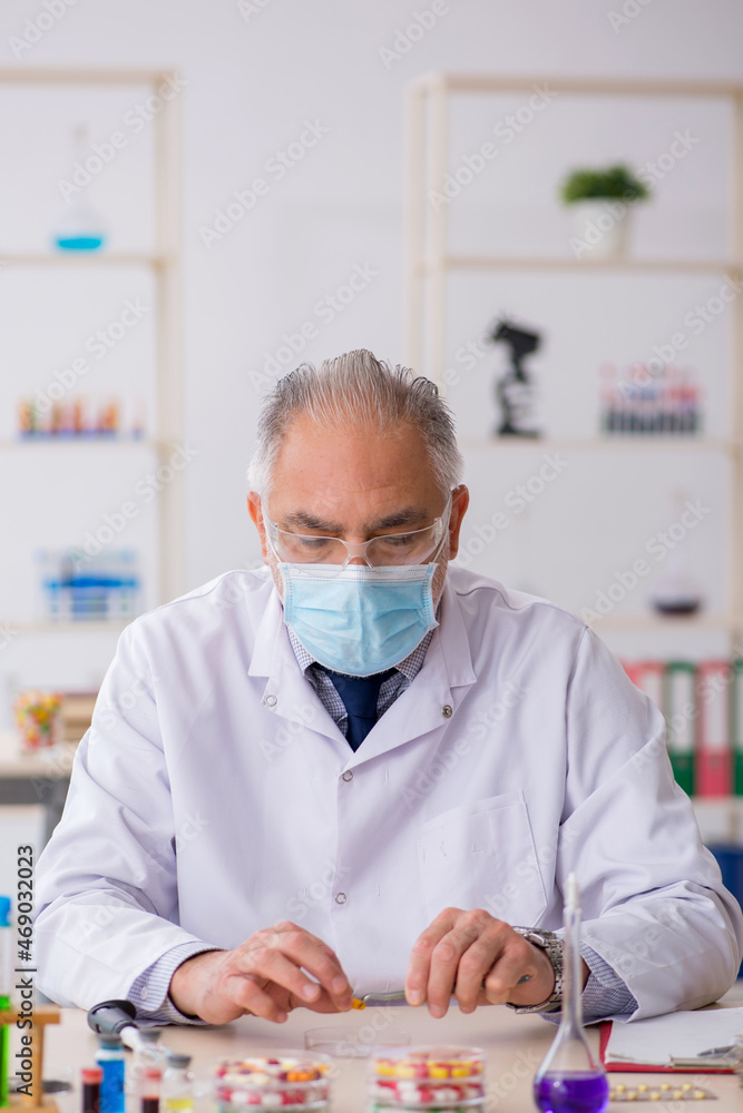 Old male chemist in drug synthesis concept Old male chemist in drug synthesis concept