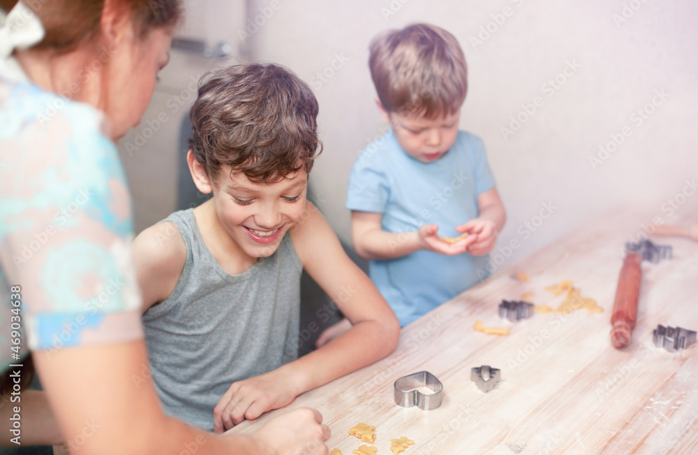 Children with their mother are happily making cookies Children with their mother are happily making cookies