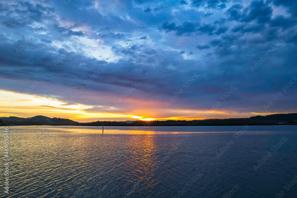 Sunrise waterscape with colourful cloud covered sky Sunrise waterscape with colourful cloud covered sky